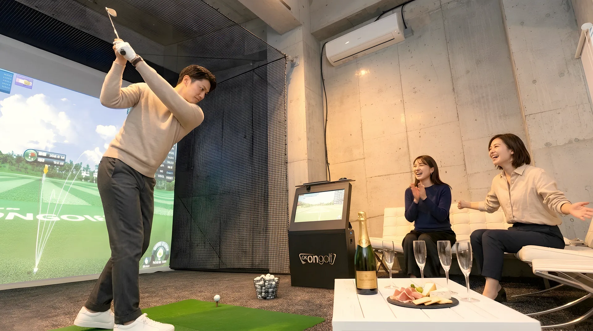 ソファでくつろぐ友人が見守るなか、シミュレーターでスイングする男性