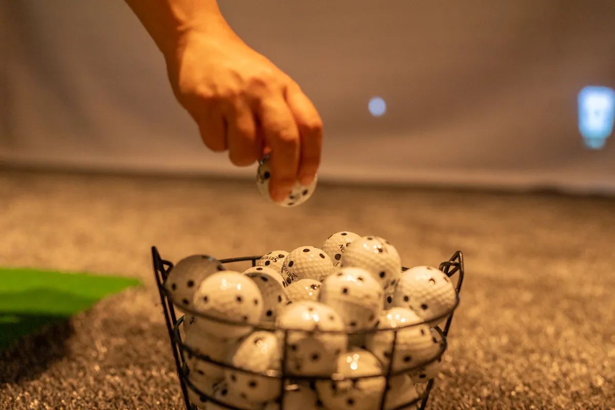 ゴルフボールをカゴに戻す様子